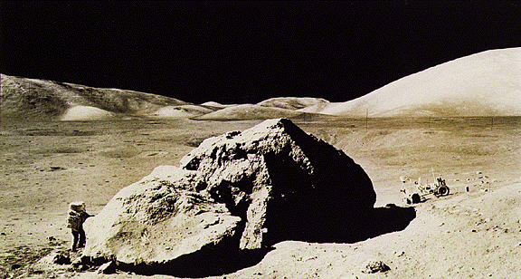 O Cientista-astronauta Harrison Schmidt fotografado perto de uma grande rocha durante uma exploração da superficie lunar feita por ele e pelo companheiro, o astronauta da Apollo 17, Eugene Cernan. Esta grande rocha foi chamada “Split Rock” (Pedra Rachada). Cientistas analisaram amostras tiradas da "Split Rock" e concluiram que ela foi formada por solidificação de material de impacto. Isto quer dizer que "Split Rock" foi formada por rocha derretida, lançada pelo impacto de um meteorito. Ao fundo vemos o jipe lunar que foi utilizado pelos astronautas para se deslocarem para longe do local de pouso e coletar amostras lunares.